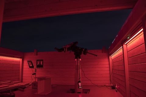 Teleskop auf Stativ unter rotem Licht