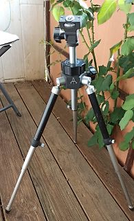 Stativ auf Holzterrasse vor Pflanzen