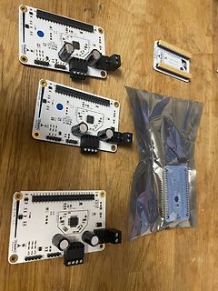 Drei Trinamic Entwicklungsboards und ein Header auf Holzuntergrund