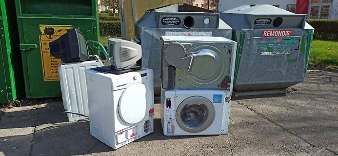 Elektroschrott vor Müllcontainern