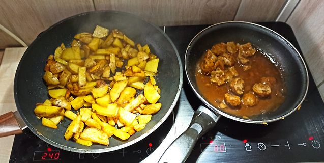 Zwei Pfannen mit Essen auf einem Induktionskochfeld