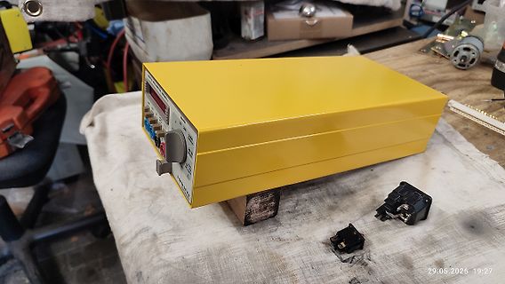 Gelbes Labornetzteil auf Werkstattunterlage