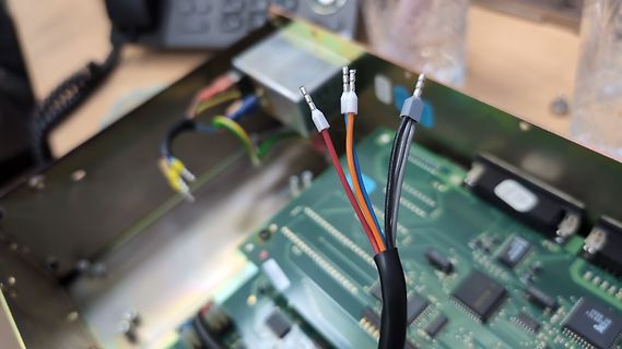 Offenes Elektronikgehäuse mit Leiterplatte und Kabeln