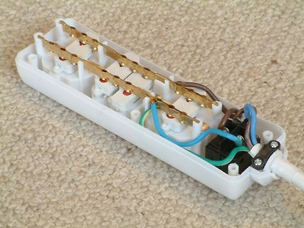 Geöffnetes Gehäuse einer Steckdosenleiste mit internen Leitern