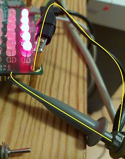 Leuchtende LEDs auf einer Leiterplatte mit Messspitze