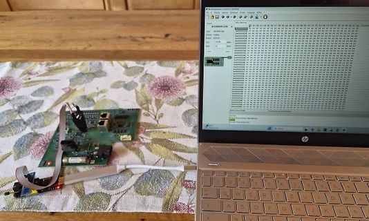 Leiterplatte mit Flachbandkabel und Laptop mit Software