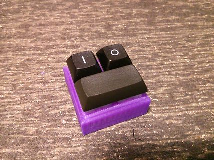 Drei Tastenkappen auf violettem Gehäuse