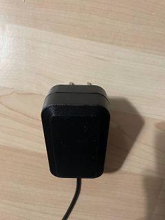 Schwarzes Netzteil auf Holztisch