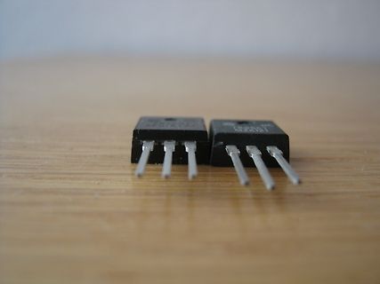 Zwei elektronische Bauteile auf Holzuntergrund