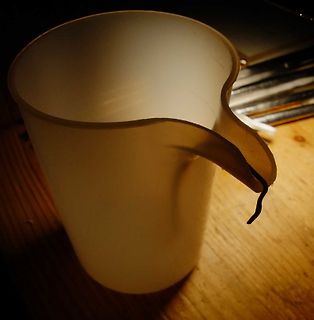Weißer Kunststoffbecher auf Holztisch