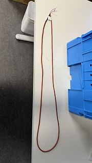 Rotes Kabel mit Steckverbindung auf weißem Tisch