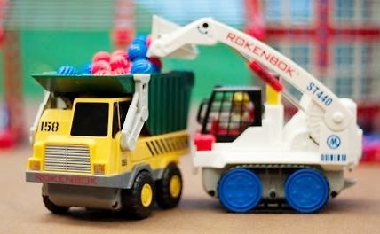 Spielzeug LKW und Bagger mit bunten Steinen