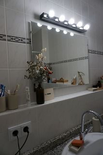 Badezimmer mit Spiegel und Waschbecken