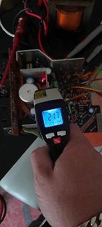 Hand hält Infrarot-Thermometer über Leiterplatte
