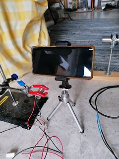 Elektronik-Versuchsaufbau mit Smartphone auf Stativ