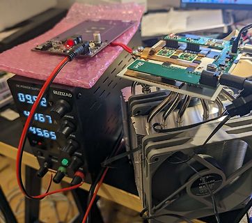 Laboraufbau mit Netzteil, Leiterplatten und CPU-Kühler