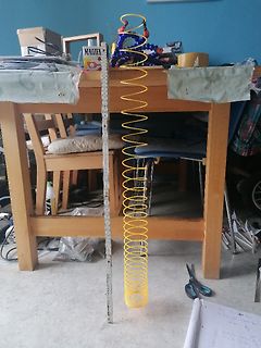 Gelbe Slinky-Feder und Metalllineal auf Tisch