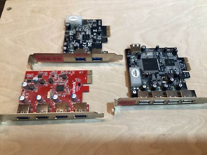 Drei verschiedene USB-Erweiterungskarten auf Holzuntergrund