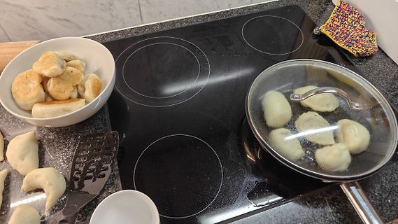 Teigwaren in Schüssel und Pfanne auf Kochfeld