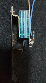 Bauteil mit blauem Kristall und Metallhalterung
