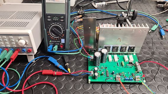 Elektronik-Aufbau mit Netzteil, Multimeter und Leiterplatte