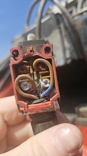 Geöffnetes, beschädigtes elektrisches Bauteil mit korrodierten Leitungen