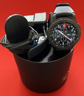 Smartwatch mit Ladekabel auf schwarzem Behälter