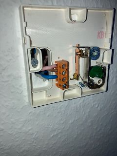 Geöffneter Elektroanschluss mit Klemmen und Kabeln