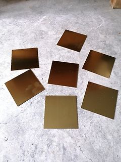 Goldfarbene quadratische Plättchen auf Betonboden