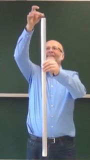 Mann hält eine weiße Stange hoch