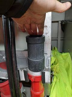 Hand hält schwarzes Kunststoffteil an Gerät