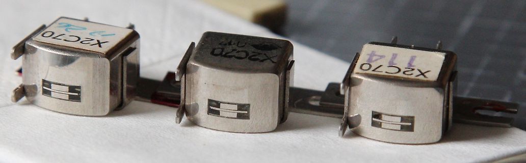 Drei metallische Bauteile mit der Aufschrift X2C70