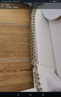 Spiralisiertes Kabel an weißem Gehäuse auf Holzuntergrund