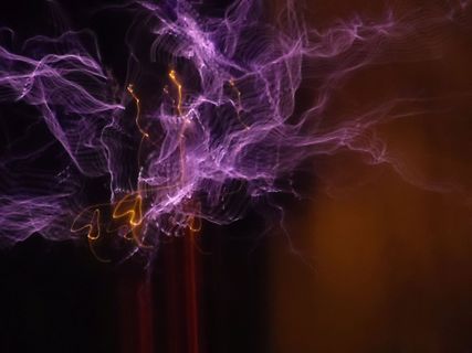 Abstraktes Lichtspiel mit violetten und gelben Lichtspuren