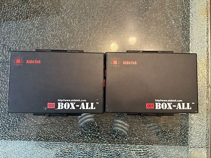 Zwei AidTek BOX-ALL Geräte auf Glastisch