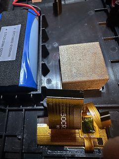 Innenansicht eines elektronischen Geräts mit Akku und Flexkabel