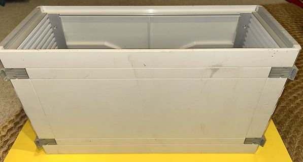 weiße Kunststoffbox auf gelbem Untergrund