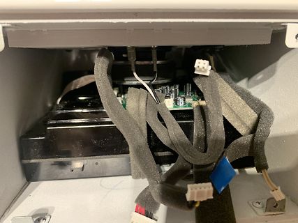 Innenansicht eines elektronischen Geräts mit Kabeln und Platine