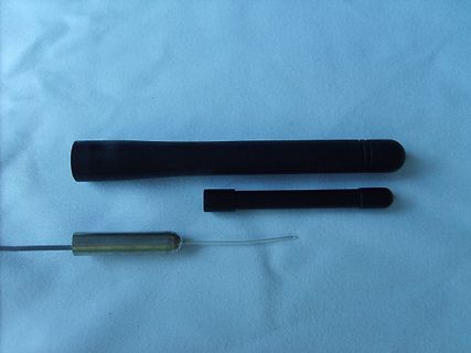 Zwei schwarze Stifte und ein Bauteil auf hellem Grund