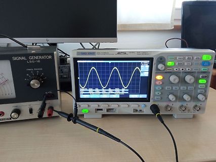 Signalgenerator und Oszilloskop auf einem Arbeitstisch