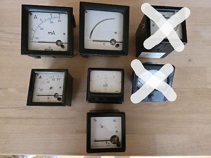 Verschiedene analoge Messinstrumente auf Holztisch