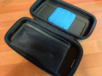 Schwarzes Etui mit blauem Behälter auf Holztisch