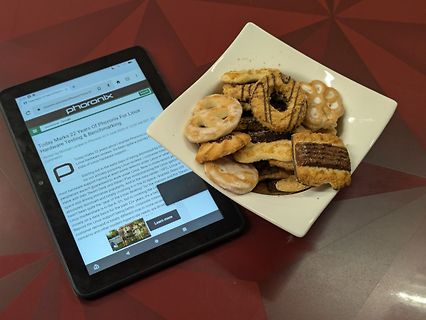 Tablet mit Phoronix Artikel und Schale mit Gebäck