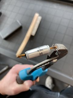 Hand hält Kondensator mit Kombizange