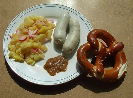Bayerisches Essen mit Weißwurst, Brezel und Kartoffelsalat