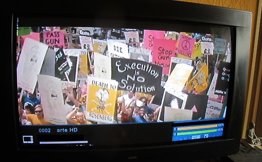 Foto eines Fernsehbildschirms mit Protestplakaten