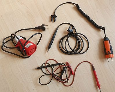 Diverse Messleitungen und Netzkabel auf Holzboden