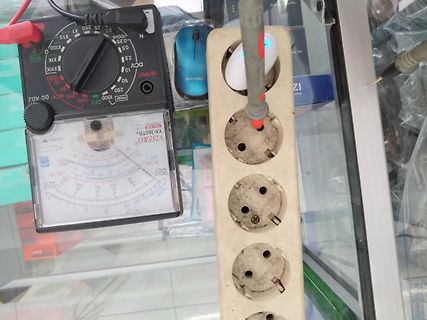 Multimeter und Steckdosenleiste auf Arbeitstisch