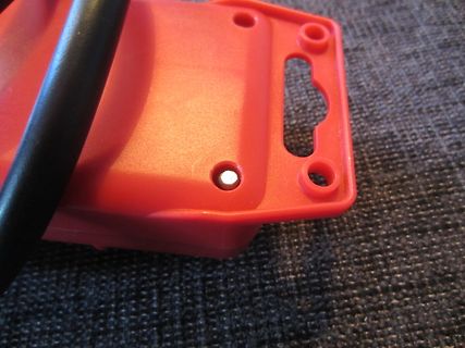 Rote Kunststoffhalterung mit schwarzem Kabel