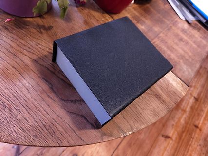 Schwarzes Buch auf Holztisch